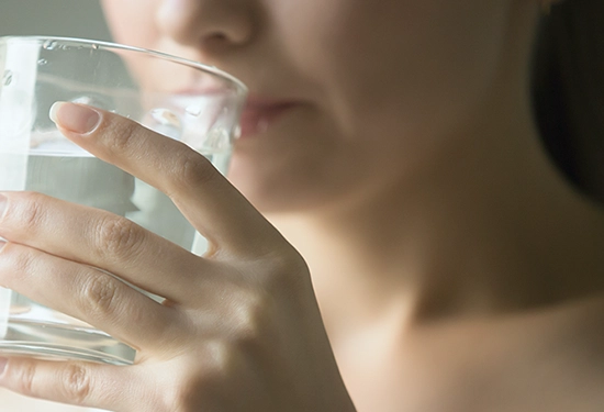 A person drinks a glass of water.